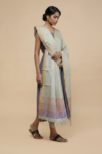 Woman wearing a long, light-colored Dupatta with a subtle pattern on a beige background