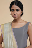 Woman wearing a gray top and colorful Dupatta against a beige background